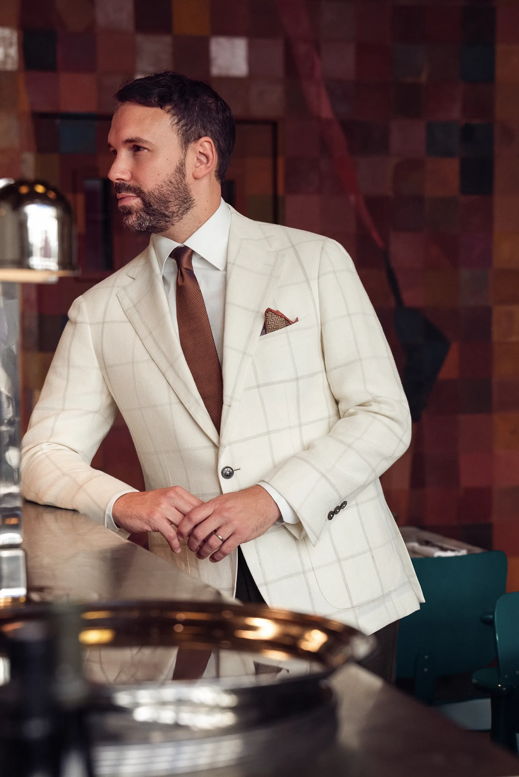 Veste sur mesure blanche à carreaux fenêtre et cravate brune, au comptoir