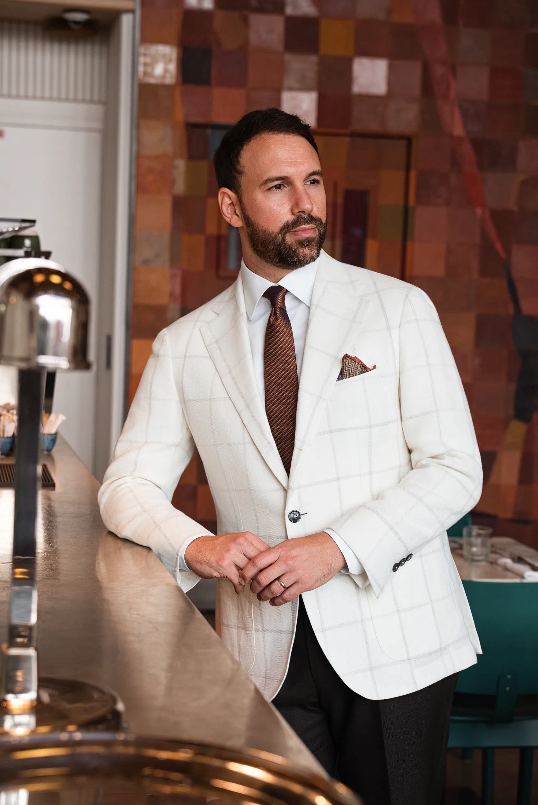 Veste sur mesure blanche à carreaux fenêtre et cravate brune, au comptoir